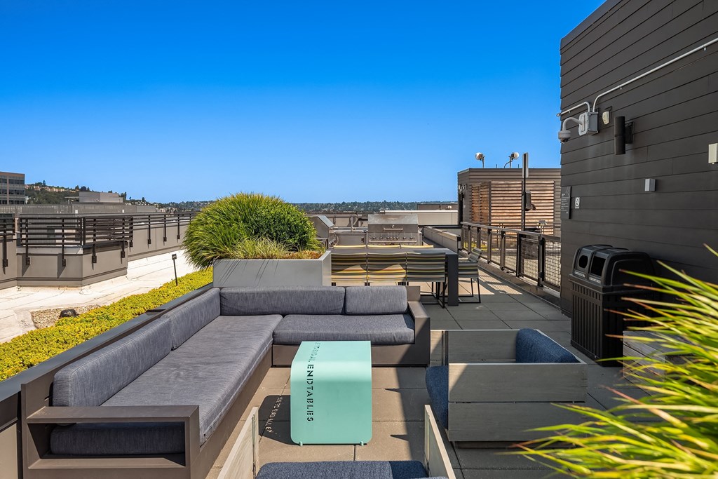 a rooftop patio with couches and a coffee table