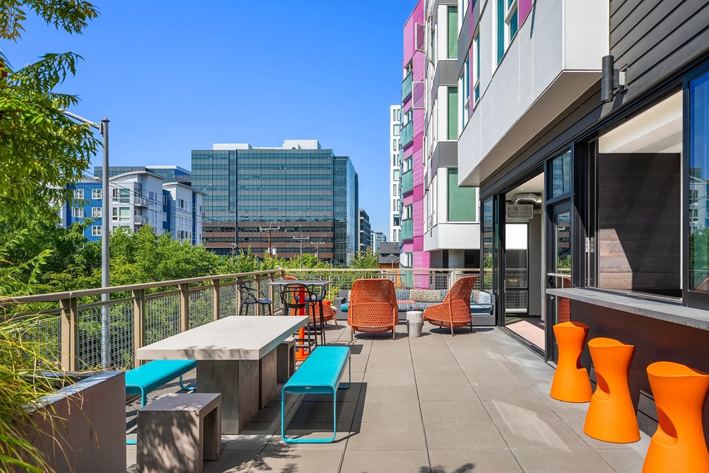 a balcony with a table and chairs and a city in the background