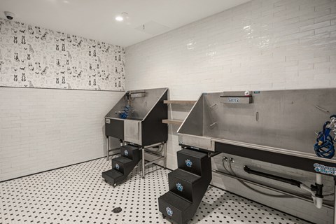 the tasting room has two stainless steel machines and a white brick wall