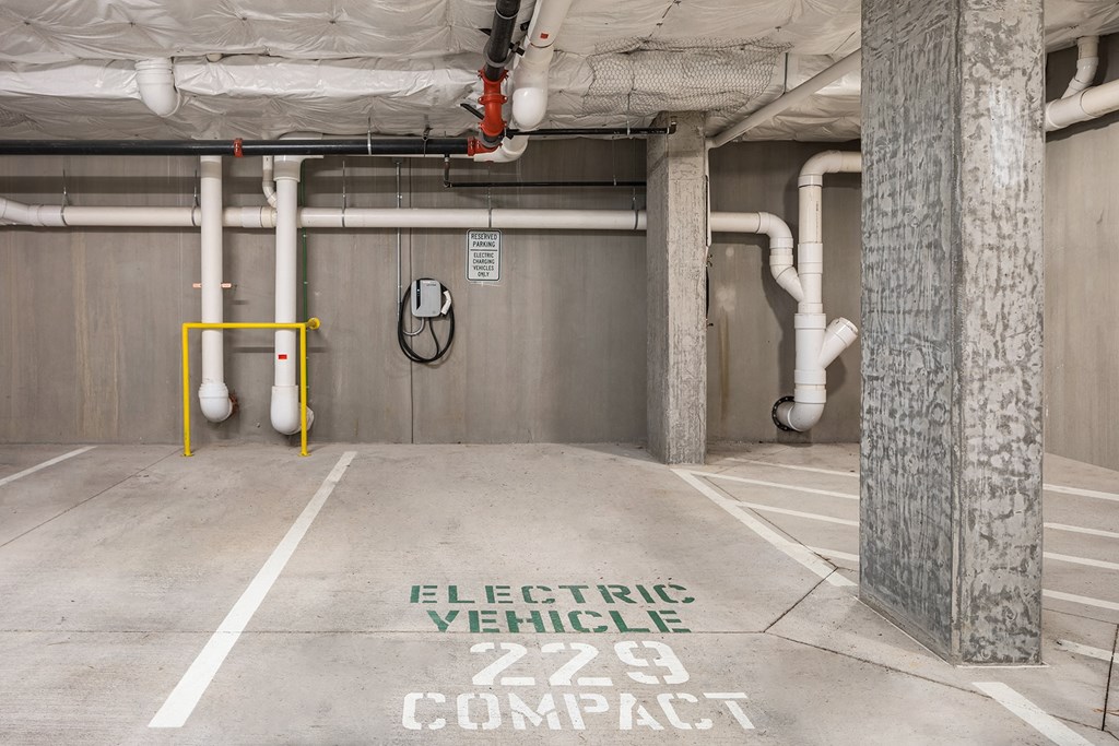 a parking garage with an electric vehicle compact sign on the floor