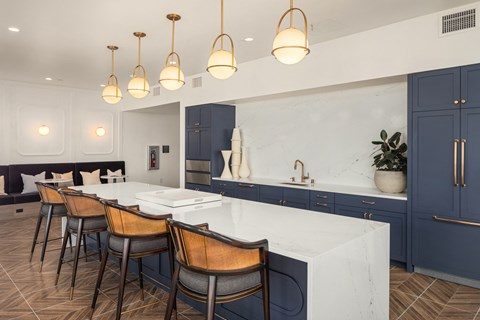 a large kitchen with blue cabinets and a marble counter top
