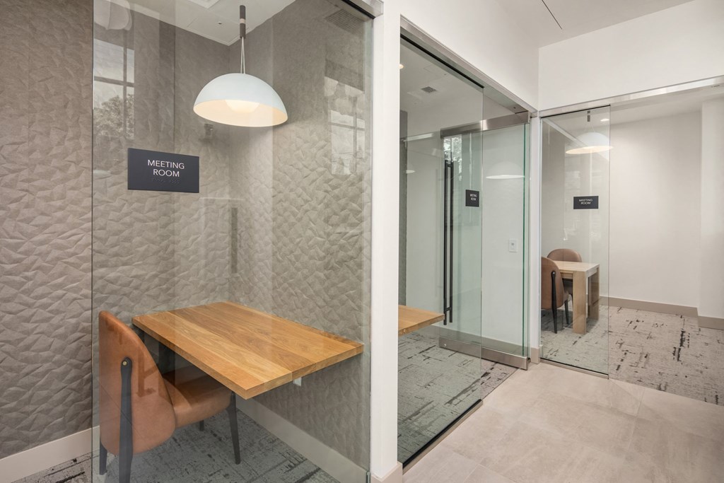 a meeting room with a wooden table and glass doors
