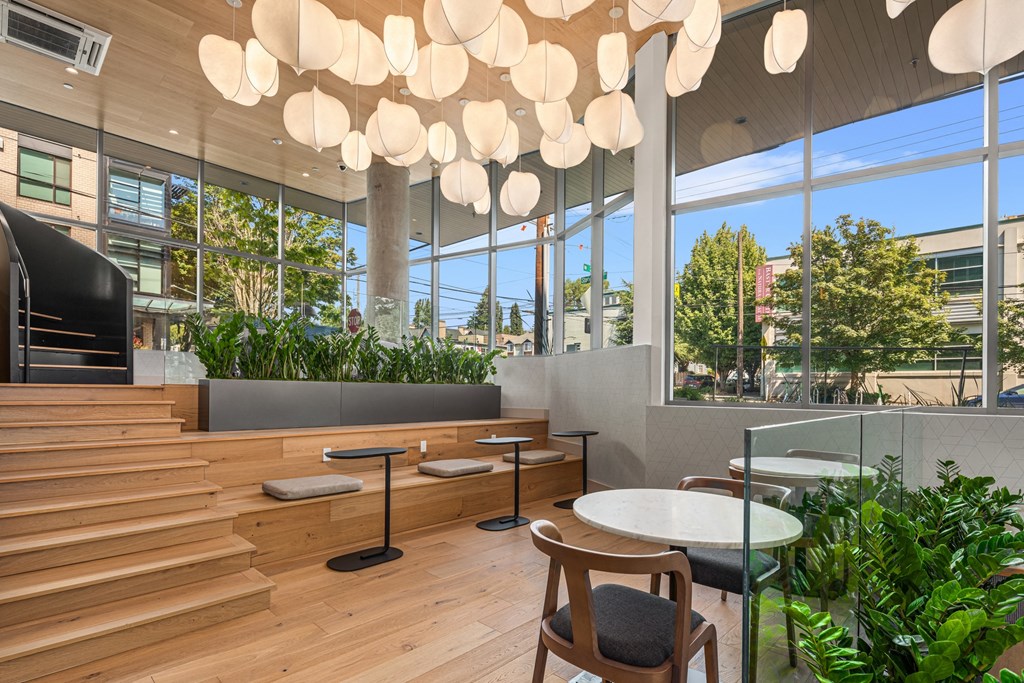 a restaurant  with wooden tables and chairs and a large window