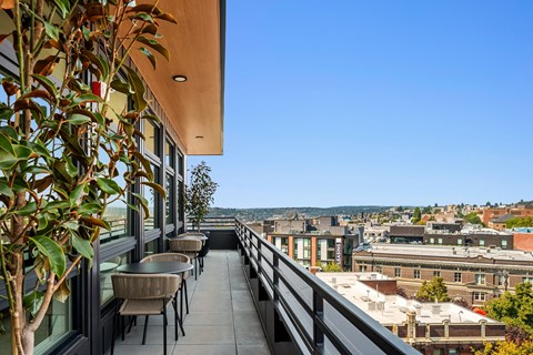 a balcony with tables and chairs and a view of the city