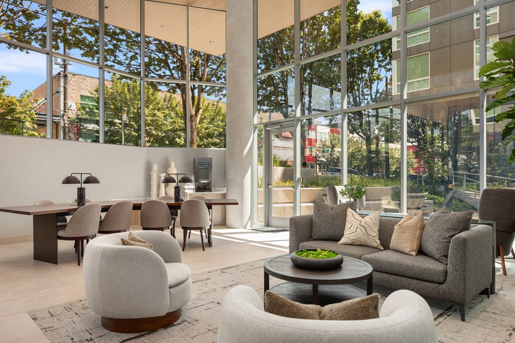 a  living room with couches and chairs and large glass windows