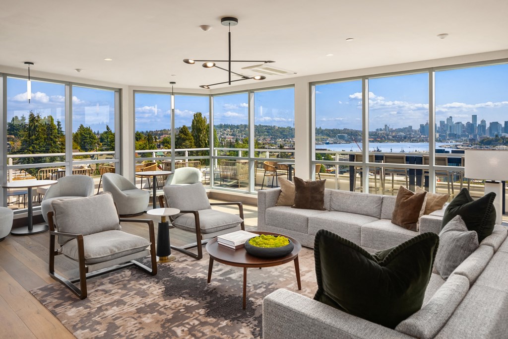 a  living room with couches and chairs and views of the water and a city