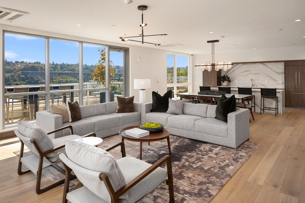 a living room with couches and chairs and a kitchen with a large window