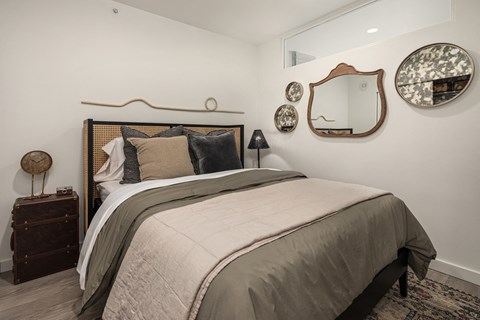 a bedroom with a bed and mirrors on the wall