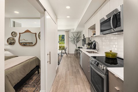 a small apartment with a kitchen and a bed