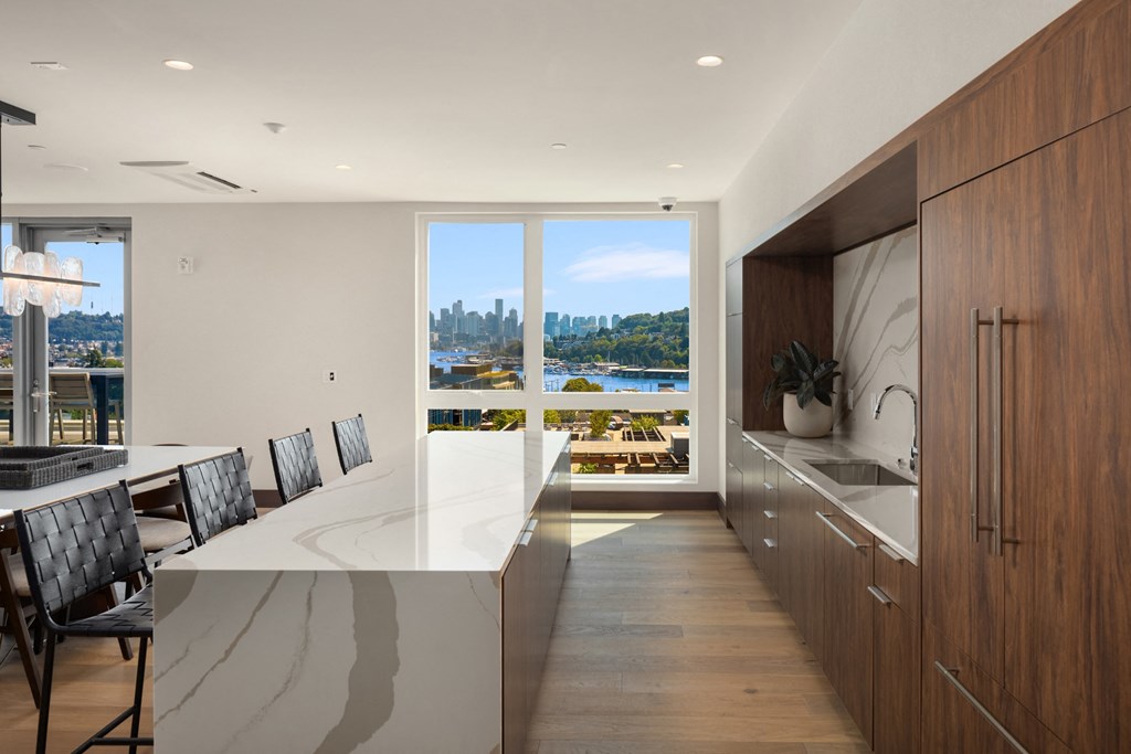 the  kitchen has a large island with a marble countertop and views of the city