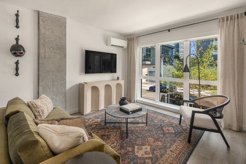 a living room with a couch and a chair and a large window