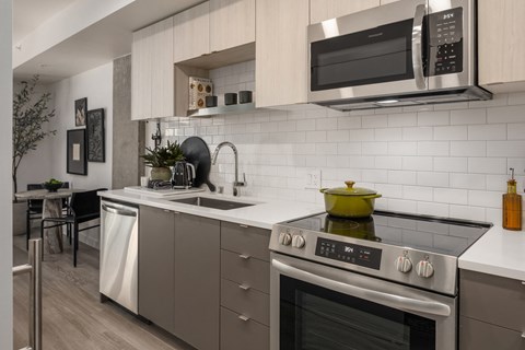 an apartment kitchen with stainless steel appliances and a sink