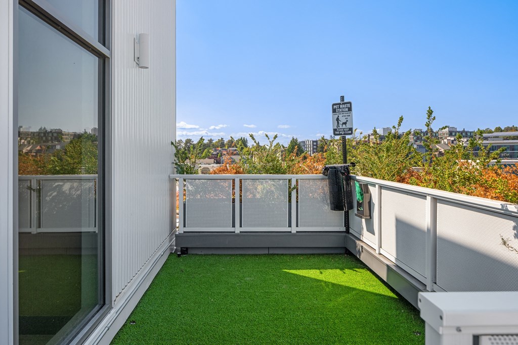 a balcony with green turf and a view of the city