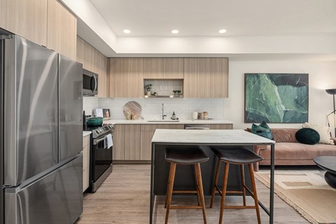 a kitchen with stainless steel appliances and a counter with three stools