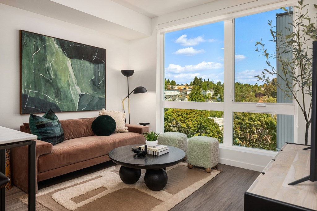 a living room with a brown couch and a large window