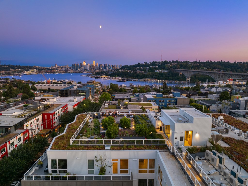 the roof of a building with a green roof and a city in the background
