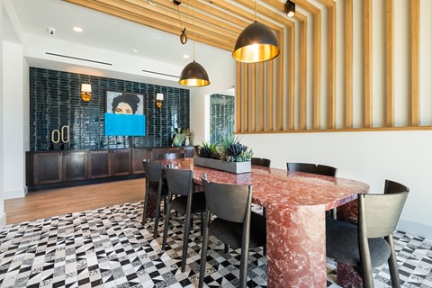 A dining room with a table surrounded by chairs.