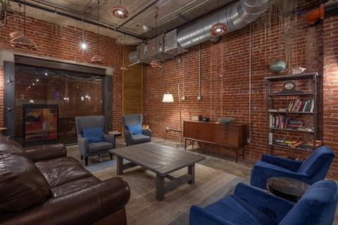 A living room with a brown leather couch and blue chairs.