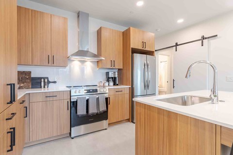 A modern kitchen with wooden cabinets and stainless steel appliances.