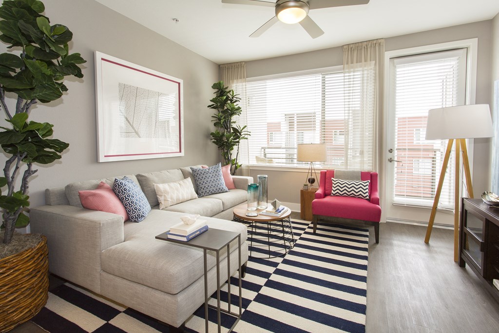 a living room with a large window and a ceiling fan