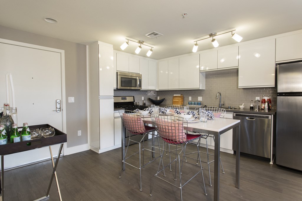 a kitchen with white cabinetry and stainless steel appliances