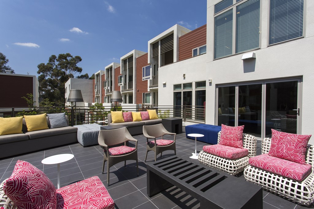 a seating area with couches and chairs in front of a building