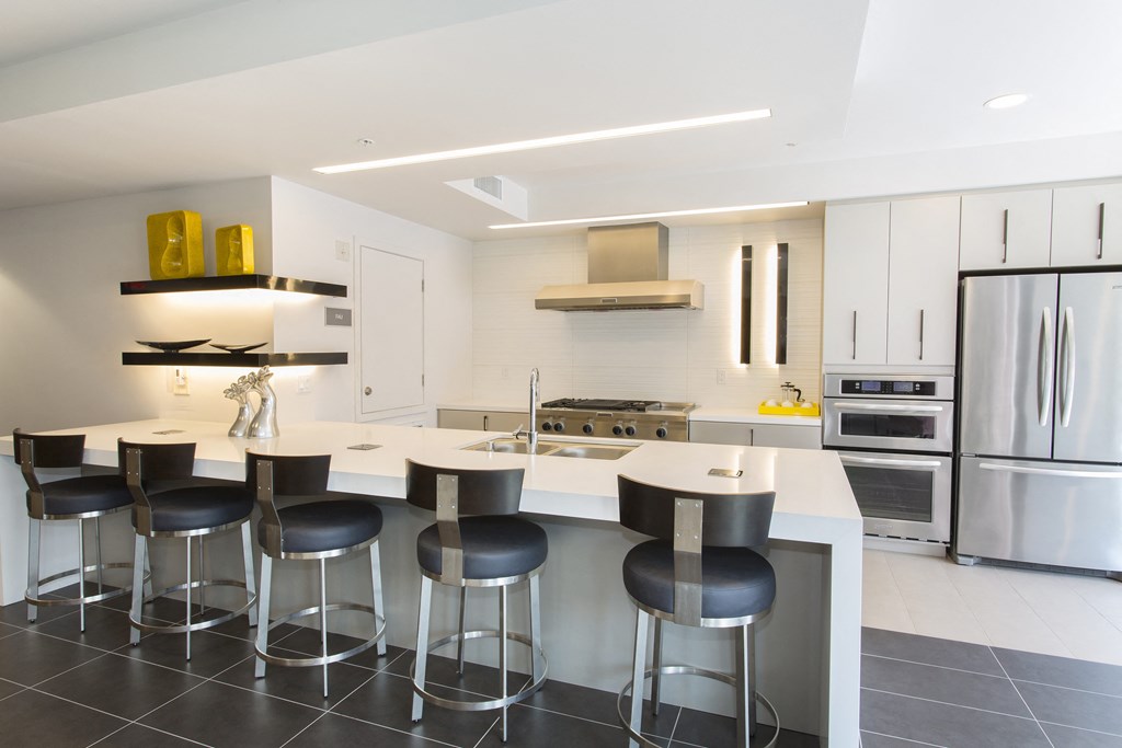 a kitchen with white cabinets and a island with a white countertop