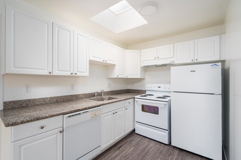 A kitchen with white appliances and cabinets.