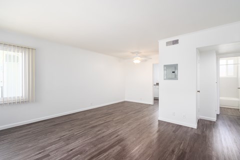 A room with wooden flooring and white walls.