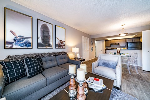A living room with a grey couch and a coffee table with candles on it.