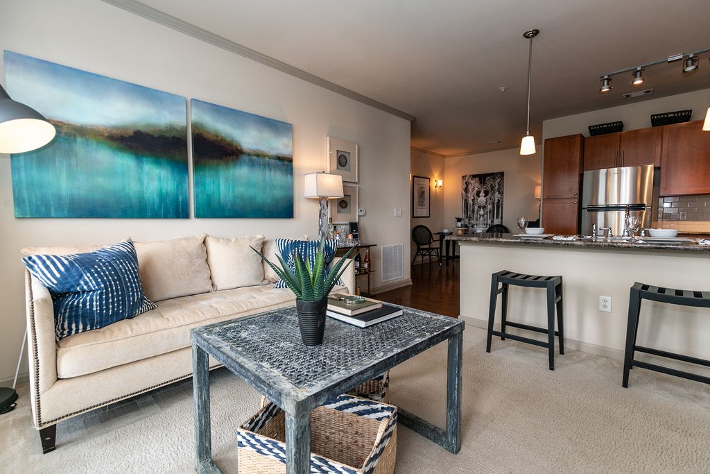 A living room with a couch, coffee table, and a painting on the wall.