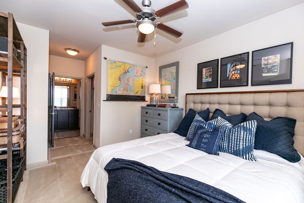 A bedroom with a large bed and a ceiling fan.