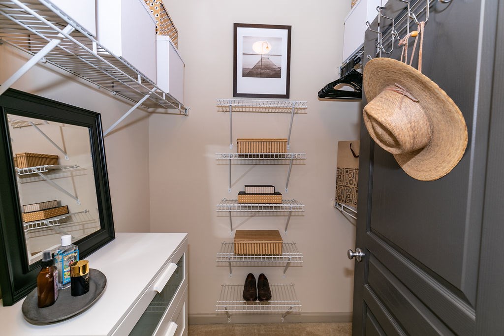 A small pantry with a hat hanging on the door.