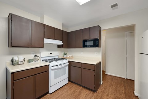 A kitchen with brown cabinets and white appliances.