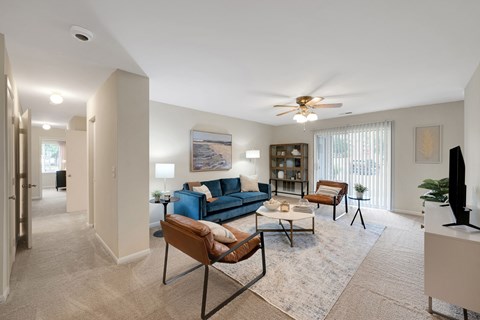 A living room with a blue couch and a ceiling fan.