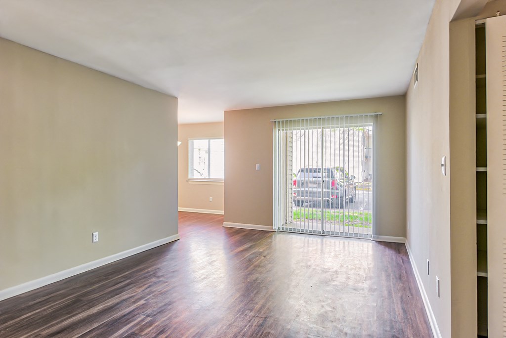 a bedroom with a sliding glass door and hardwood floors