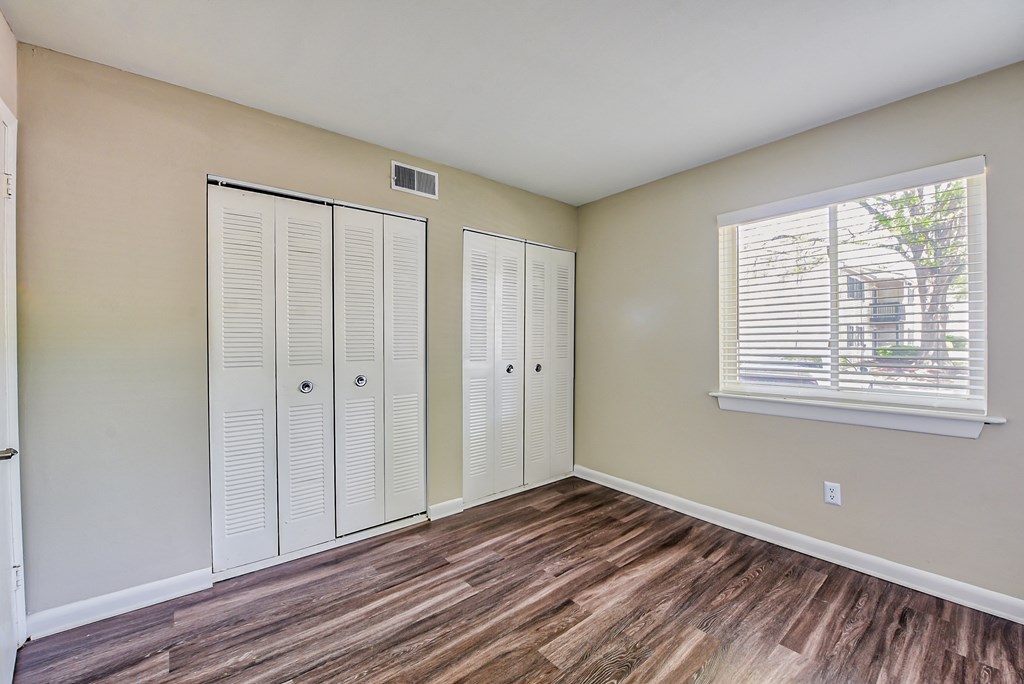a bedroom with two closets and a window