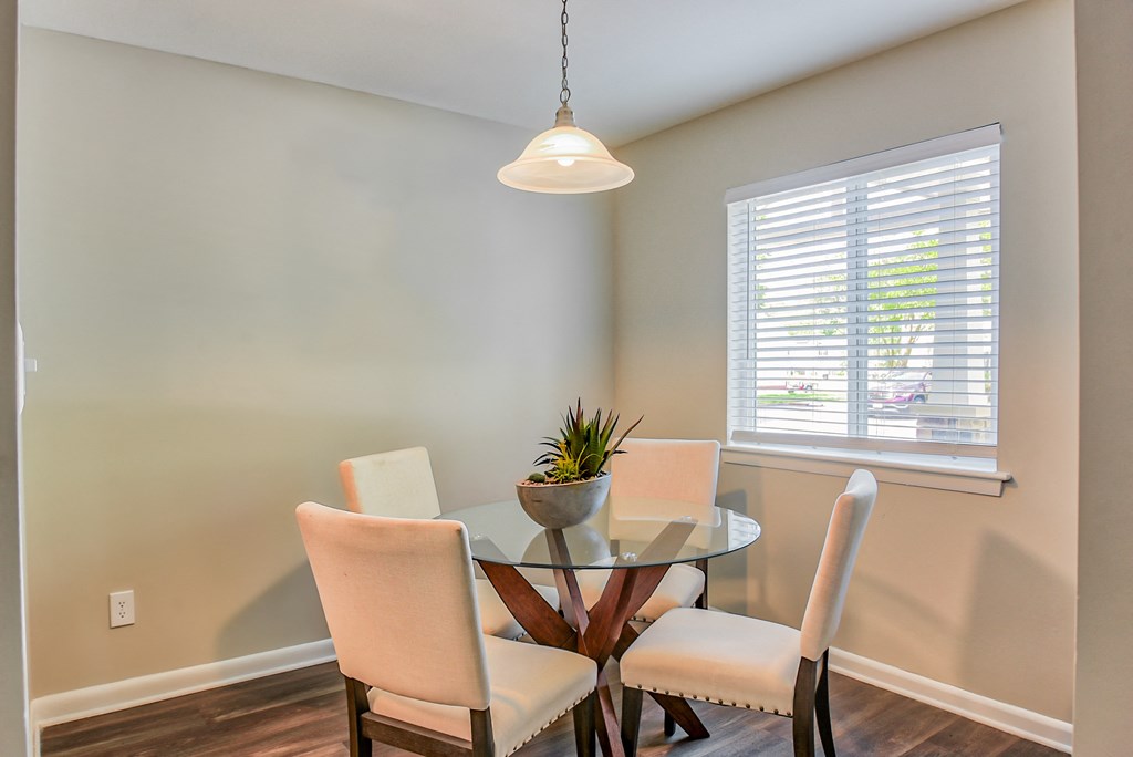 a dining room with a glass table and four chairs