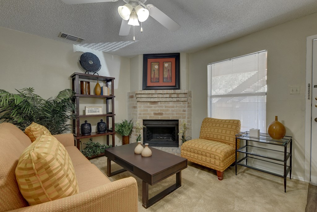 a living room with a fireplace and a ceiling fan