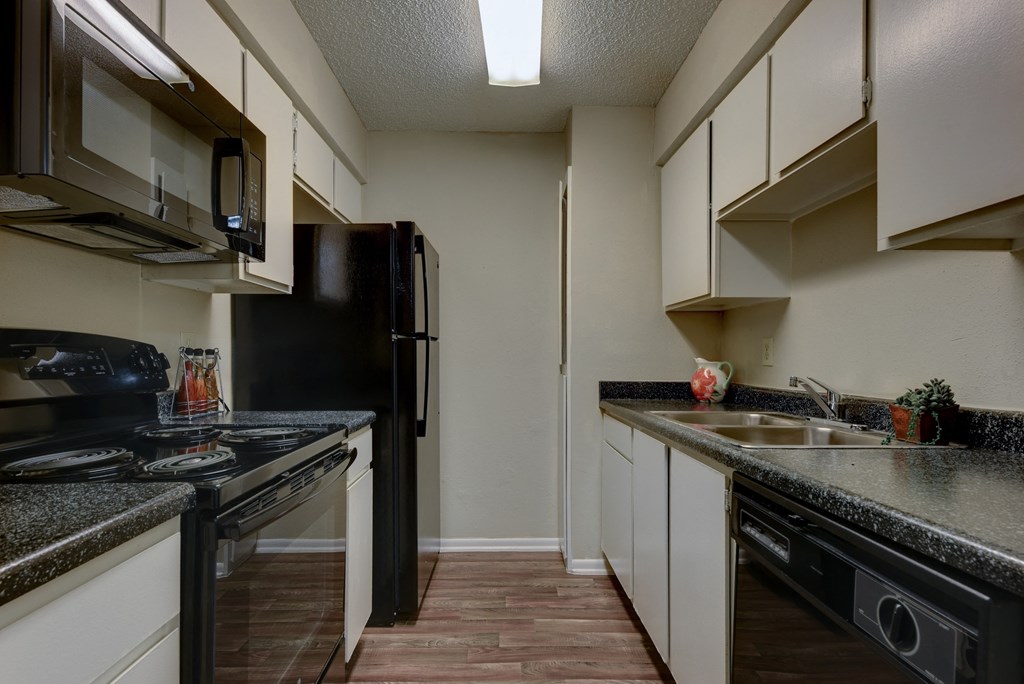 a kitchen with granite countertops and black appliances