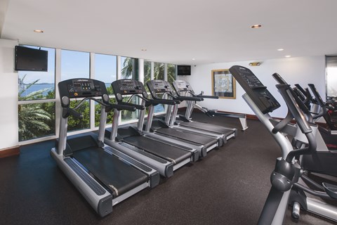 A gym with treadmills and a flat screen TV.