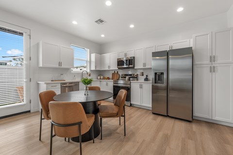 A modern kitchen with a table and chairs.