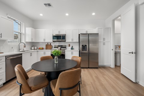A modern kitchen with a table and chairs.