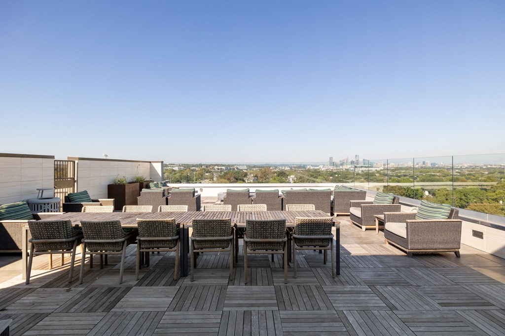 a rooftop terrace with tables and chairs and a view of the city