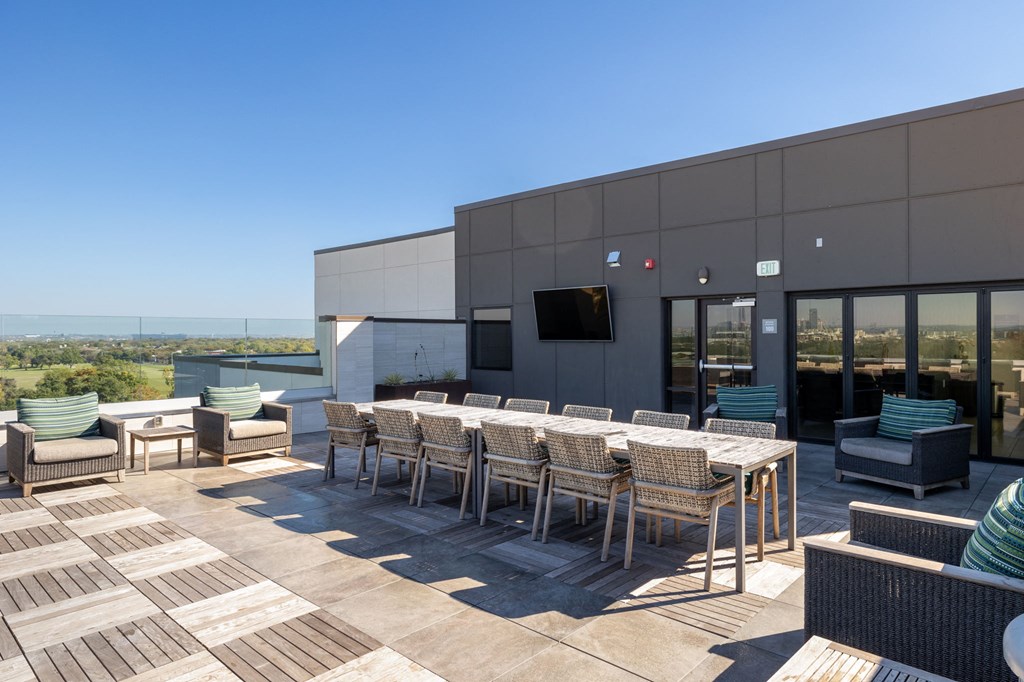 a large patio with tables and chairs and a building in the background