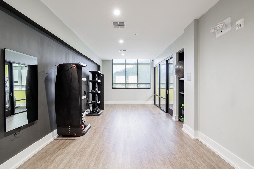 a fitness room with a punching bag and other equipment on the wall