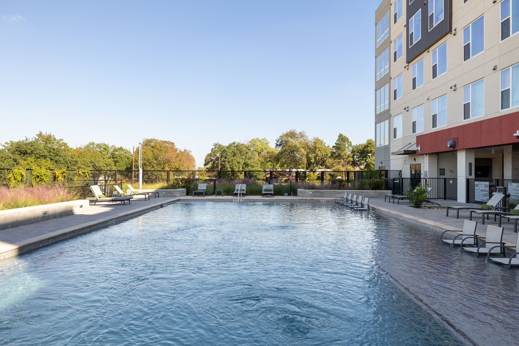 a swimming pool with a building in the background