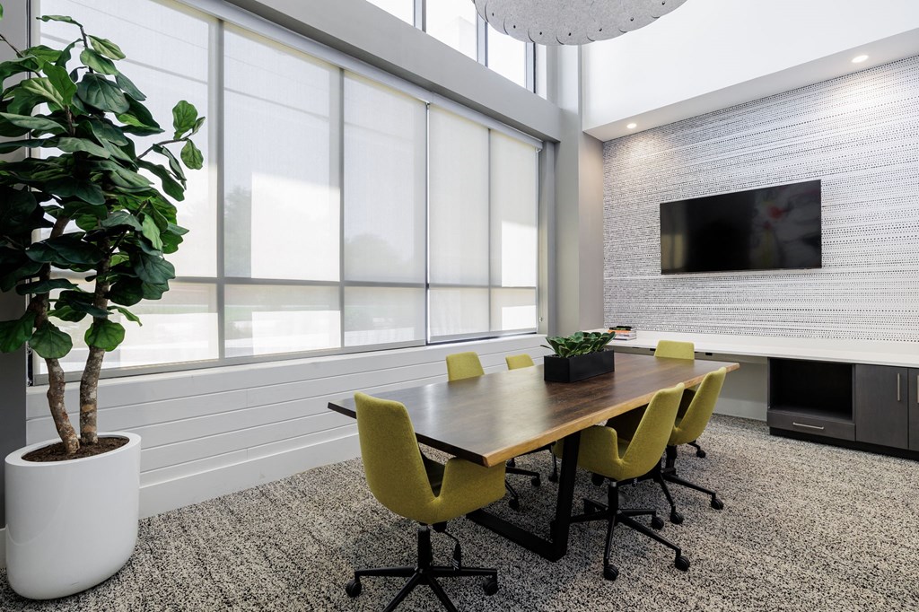 a conference room with a table and chairs and a television