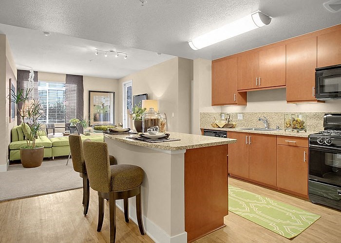 a kitchen with a center island next to a living room