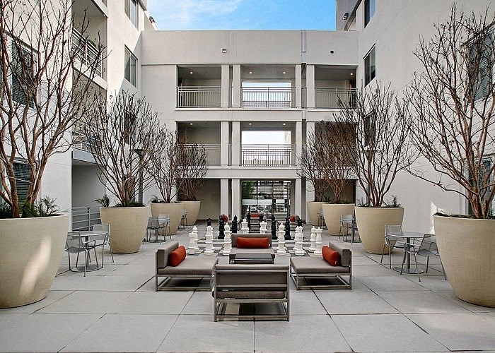 a courtyard with a large chess board in the middle of it